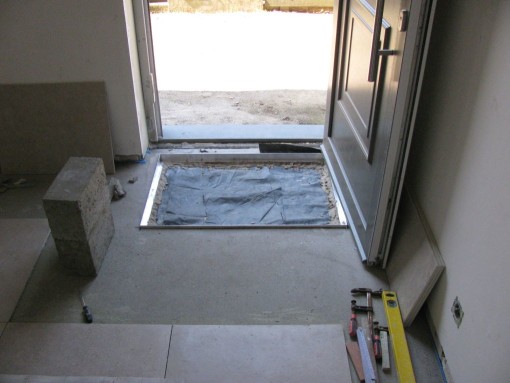 Aan de voor- en achterdeur wil ik een verlaging om een tapijt te leggen aan de deur.  Eerst een kader in aluminium L-profielen waterpas in de mortel zetten.